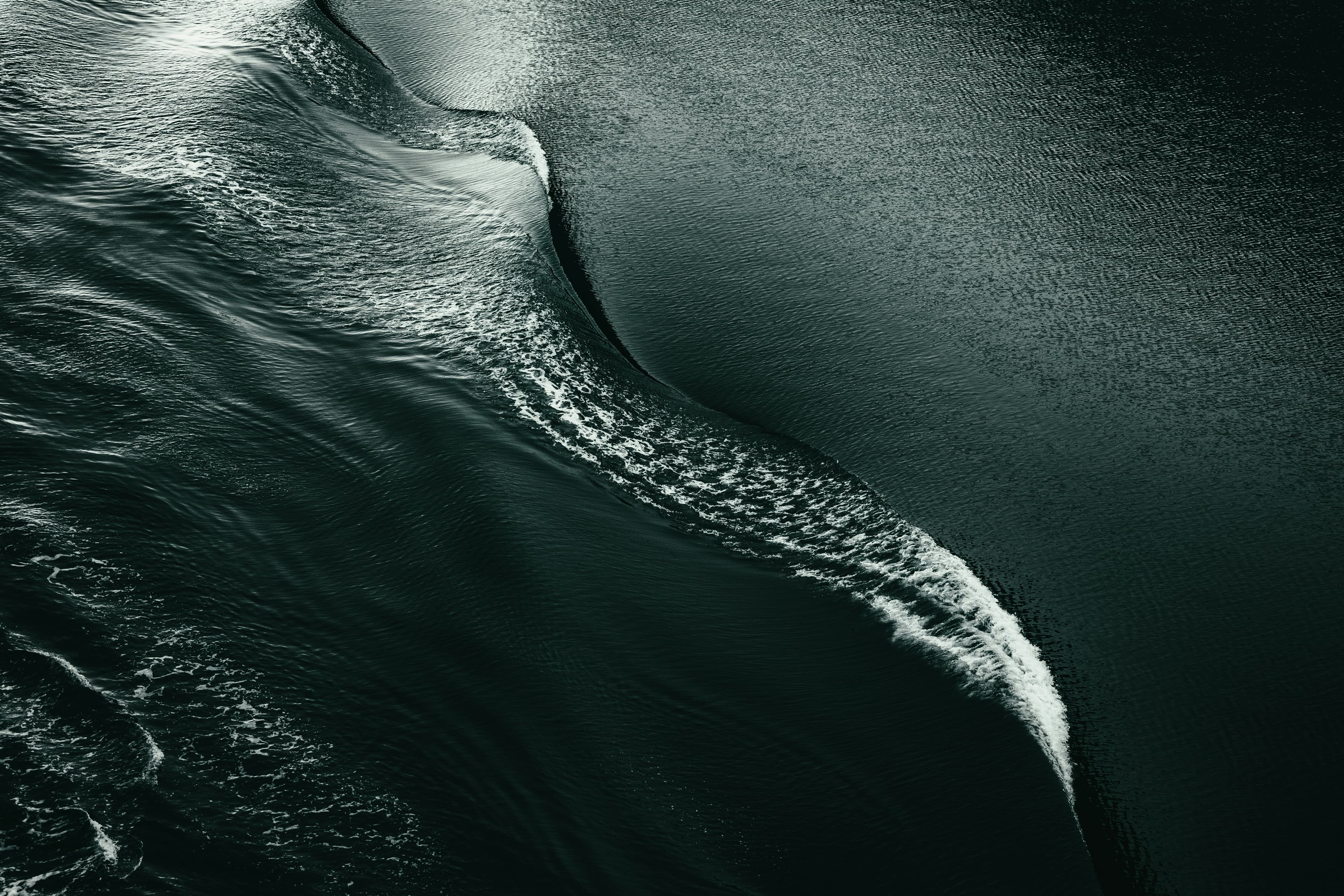 A dark fold of ocean catching one streak of light.